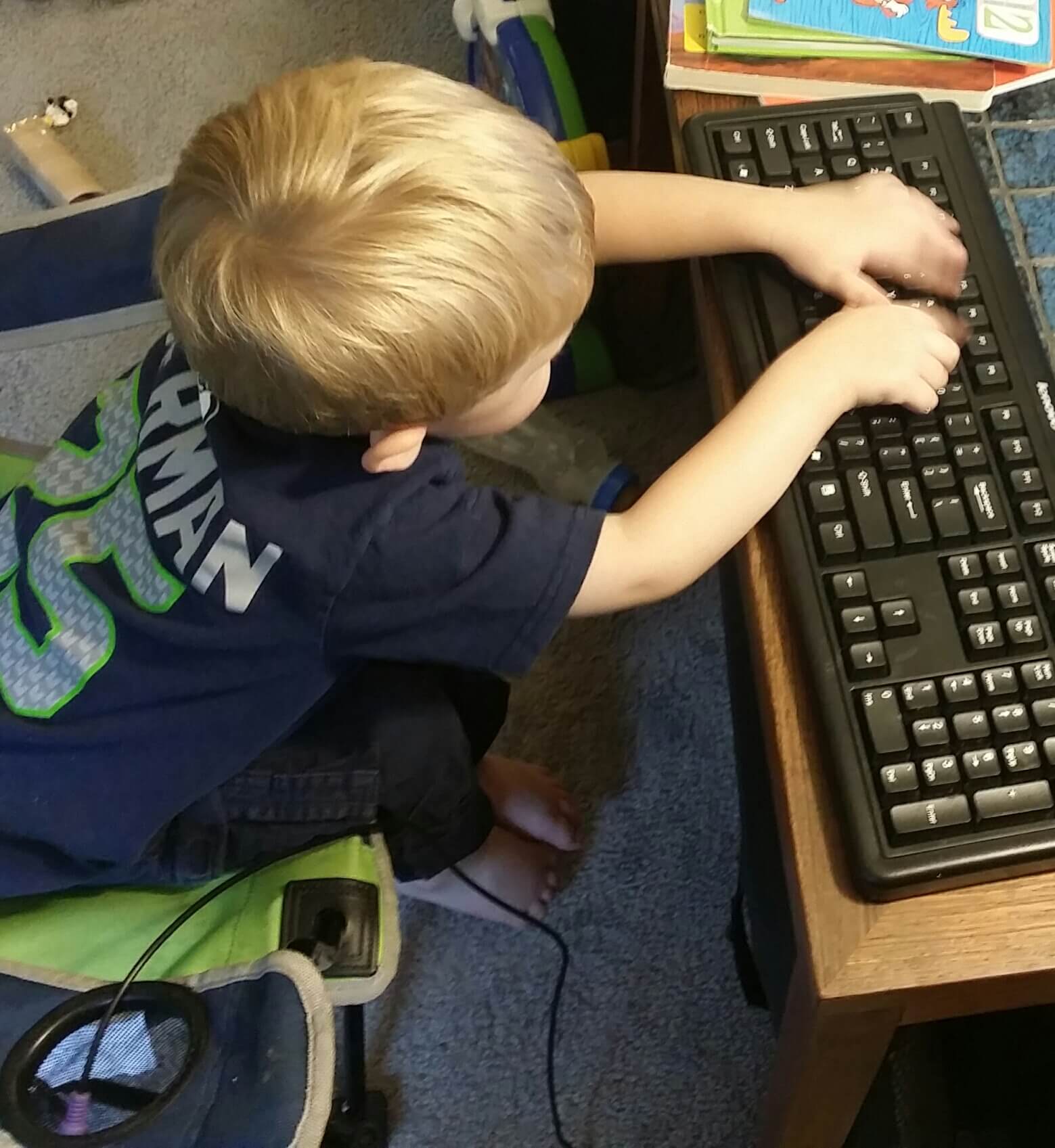 literacy station at home: 2 year old typing on an unplugged keyboard