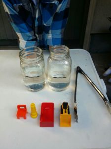 setting up a simple science experiment to measure the relative volume of objects