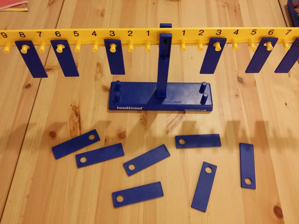 Hands-on math manipulative: a balance beam from the RightStart Curriculum with 10g weights