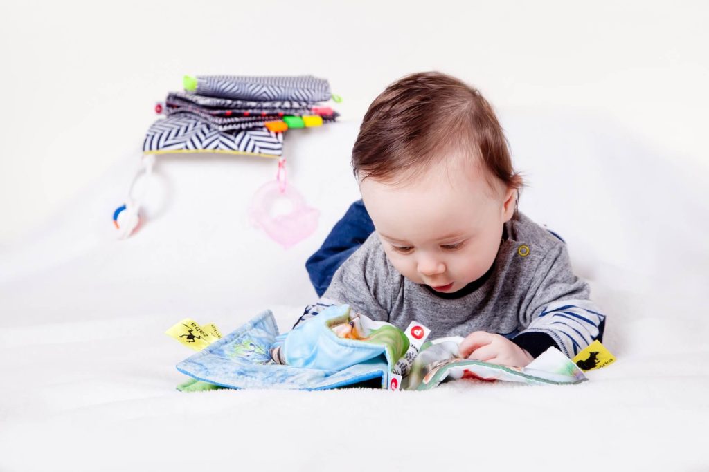 baby looking at a cloth book